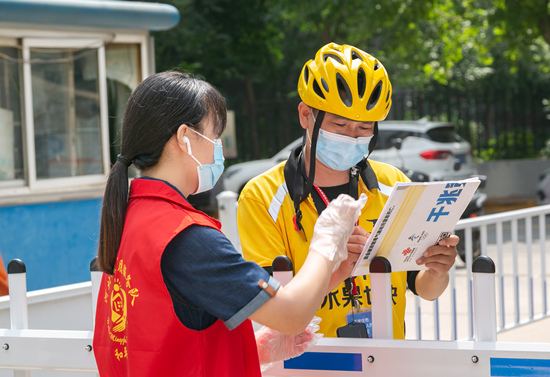 志愿者在社區門口接送快遞。石家莊市文明辦供圖